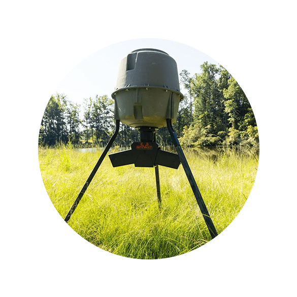Here's an alt tag for the image: Game feeder in grassy field.